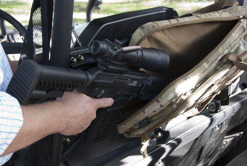 Gun being pulled out of MultiCam® Scoped Carbine Case attached to a vehicle.