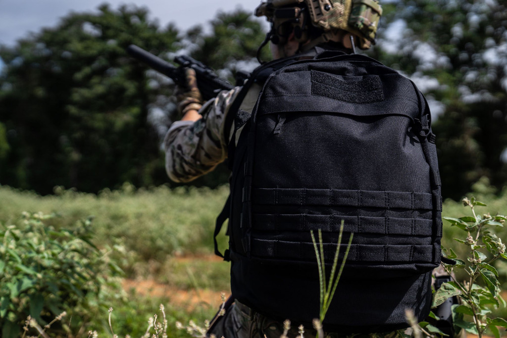 Black Pecos Backpack worn while holding rifle.