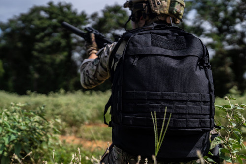 Black Pecos Backpack worn while holding rifle.