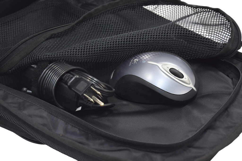 Mesh pocket inside Brazos Concealed Carry Backpack in black, shown with keyboard mouse and electrical cord.