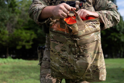 Deluxe Helmet Bag in MultCam® held open with high visibility orange interior.