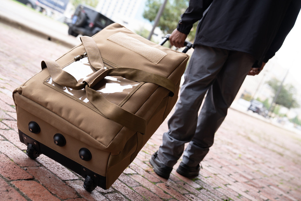 Mini Buffalo Rolling Duffel in Coyote Brown being towed with retractable handle.