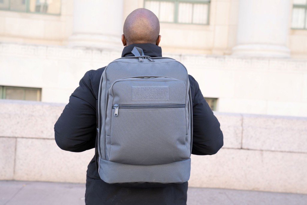 Utility Backpack in gun metal gray worn on back.