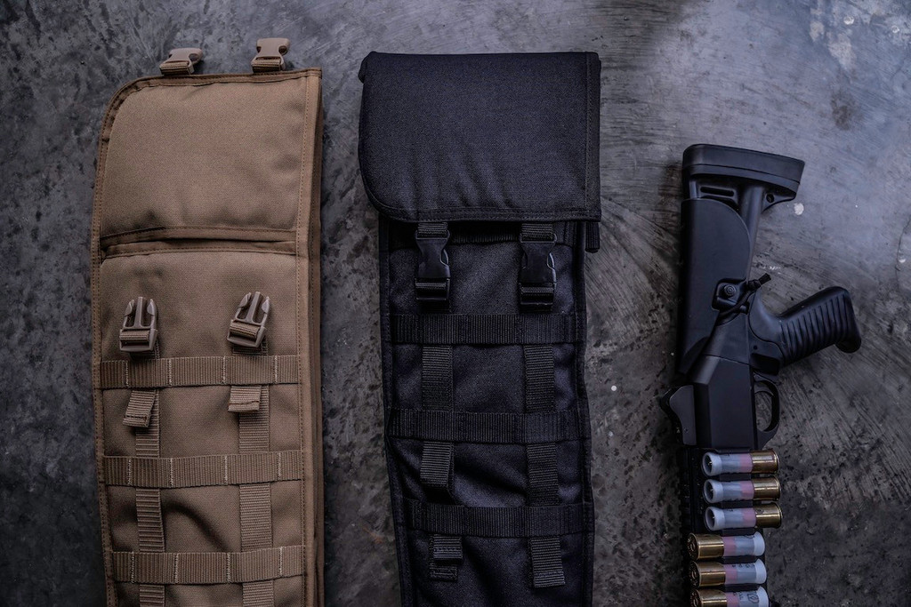 The tops of two Coyote Brown and Black Shotgun Scabbards on a grey surface next to a firearm with ammunition.