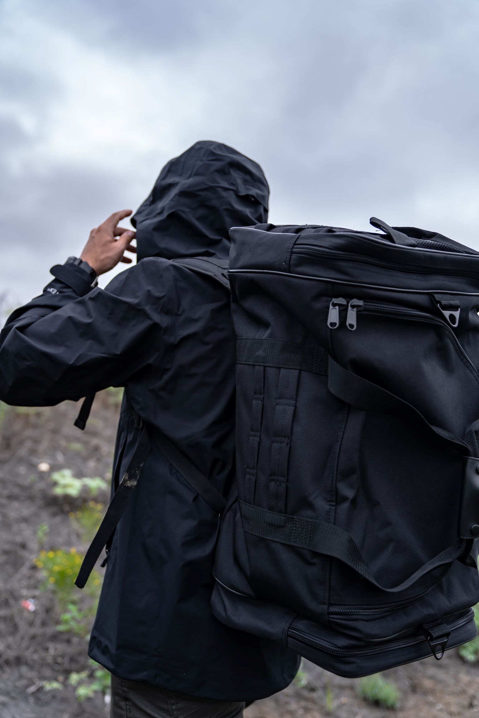 Man wearing black Goliad Duffel Backpack on back.