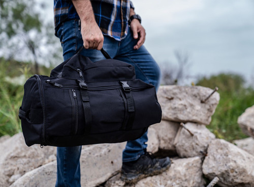 GTFO Top Load Duffel Backpack in black carried as a duffel.