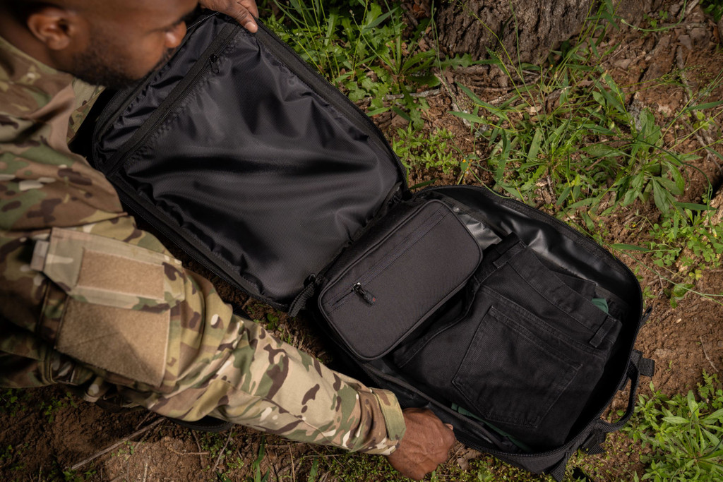 Black Midland Backpack main compartment opened and laying flat with items packed inside.