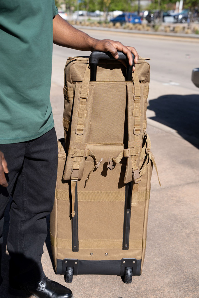 Back of coyote brown Midland Backpack sitting on top of coyote brown Mini Buffalo Rolling Duffel showing the top and bottom zippers of the back pocket of the backpack unzipped and slipped over the rolling luggage handle for easy towing.