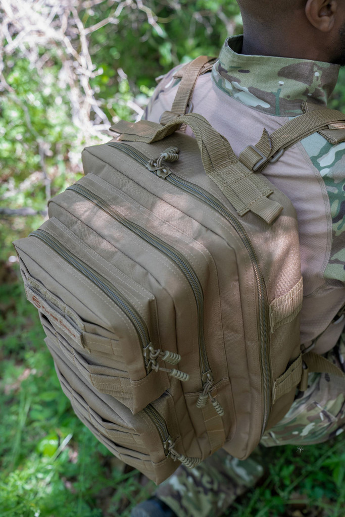 Top view of coyote brown Midland Backpack showing four zippered compartments and grab handle.